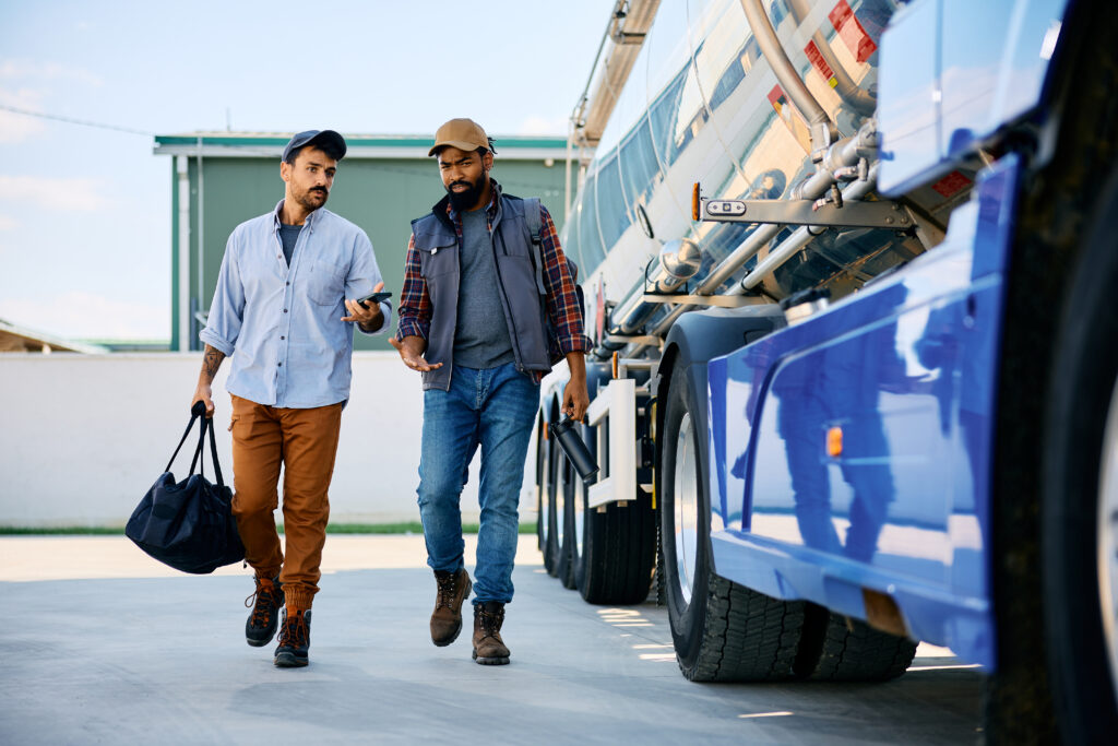 Deux chauffeurs discutant près d'un camion-citerne bleu à Nantes.